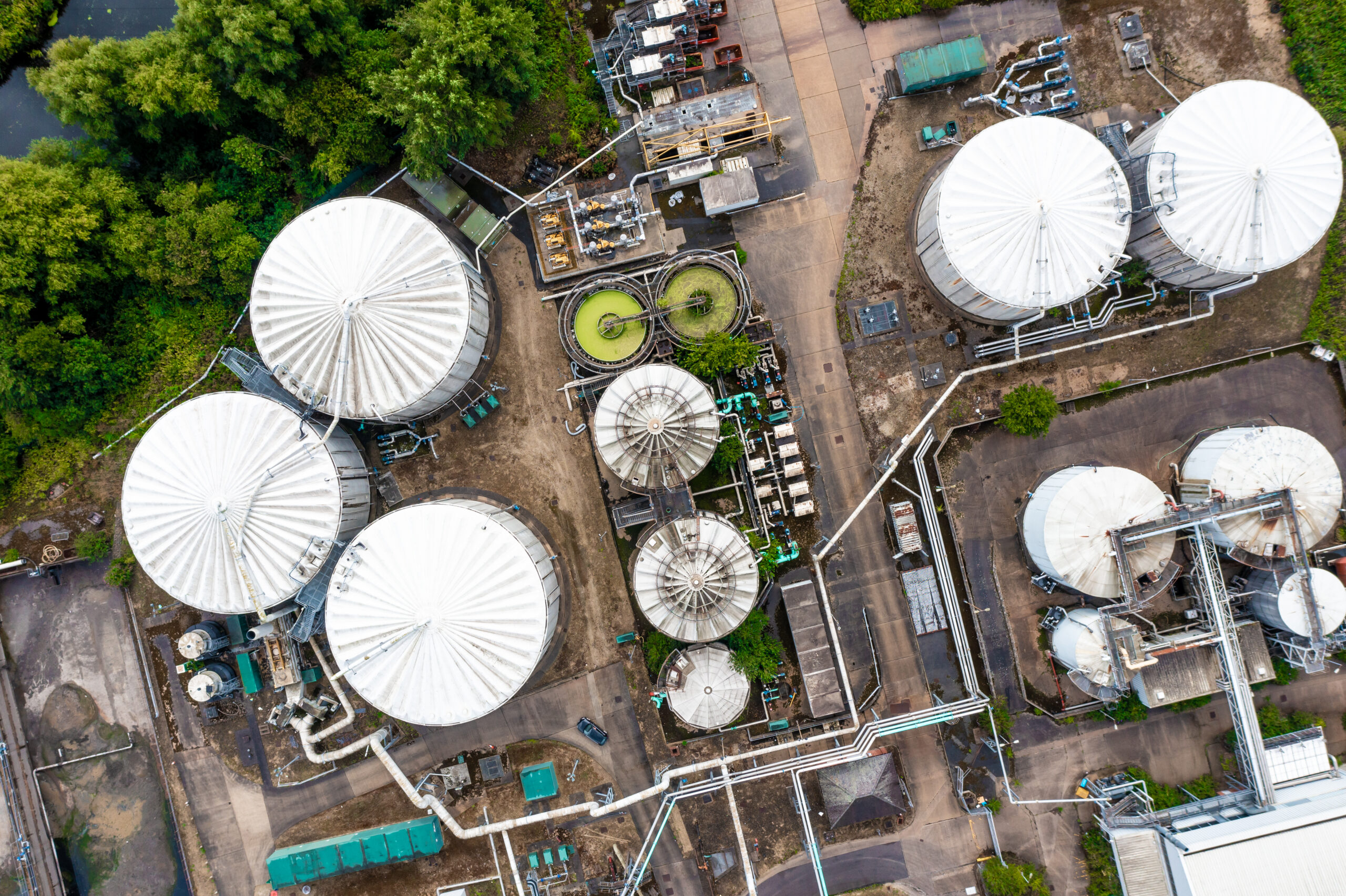 Aerial view directly above storage tanks and silos at a oil or gas terminal plant with interconnecting pipework